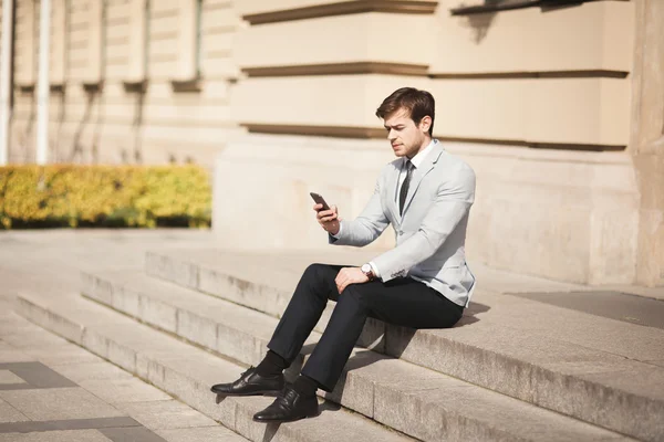 bir iş adamı elinde mobil akıllı telefon