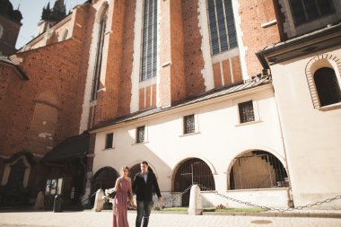 Muhteşem Düğün çifti, damat ve gelin pembe elbise Krakow eski şehirde yürüyüş ile