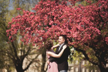 Çiçekli ağaç yakınındaki poz genç Düğün çifti