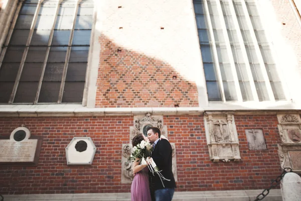 Elegante mooie bruidspaar poseren in de buurt van een kerk. Krakau — Stockfoto