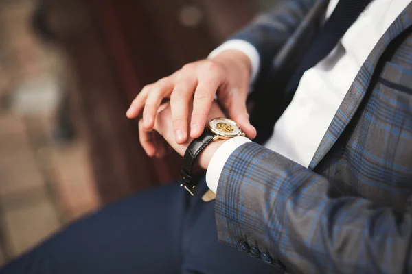 Hombre de negocios confiado mirando su reloj de pulsera en traje —  Fotos de Stock