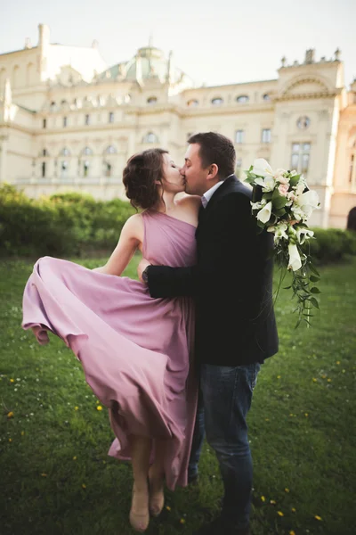 Hochzeit. Paar. Krakau. die Braut im rosa Kleid und der Bräutigam posieren vor dem Hintergrund des Theaters — Stockfoto