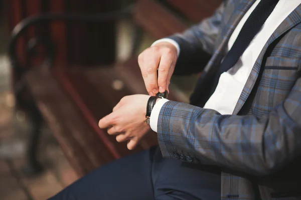 Hombre de negocios confiado mirando su reloj de pulsera en traje —  Fotos de Stock