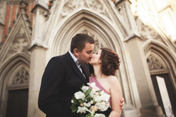 Casal lindo casamento, noivo e noiva com vestido rosa andando na cidade velha de Cracóvia — Fotografia de Stock