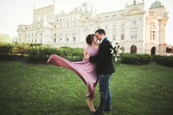 Matrimonio. Un paio. Cracovia. La sposa in un abito rosa e sposo posa sullo sfondo del teatro — Foto Stock