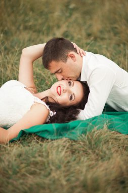 Mutlu evlilik çift yaz saati, yeşil çim üzerinde yalan