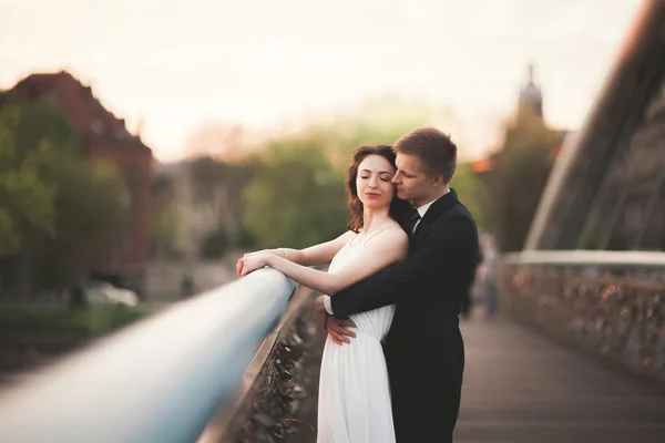 Underbara bröllop par, bruden och brudgummen poserar på bron i Krakow — Stockfoto