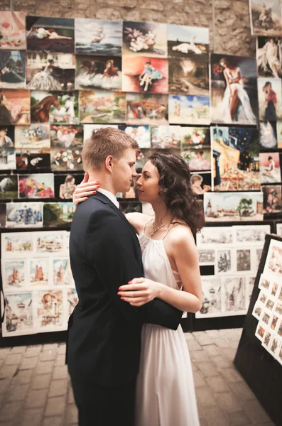 Superbe couple de mariage, mariée, marié baisers et câlins sur fond de peintures — Photo