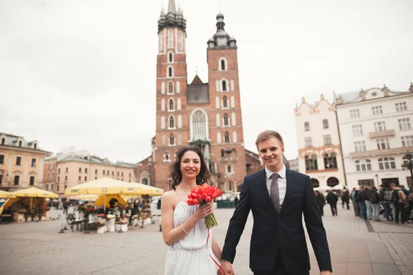 Elegante schöne Hochzeitspaar zu Fuß auf dem Hauptplatz in Krakau — Stockfoto