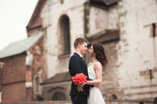 Bride and groom on the background of beautiful church. Beautiful old building. Arch. Wedding — Stock Photo, Image