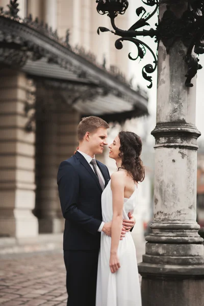 Krásná Svatební pár, nevěsta, ženich, líbání a objímání na pozadí divadlo — Stock fotografie