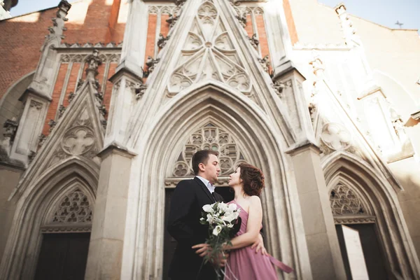 Muhteşem Düğün çifti, damat ve gelin pembe elbise Krakow eski şehirde yürüyüş ile