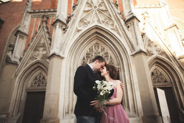 Yanında bir kilise poz zarif güzel düğün çifti. Krakow