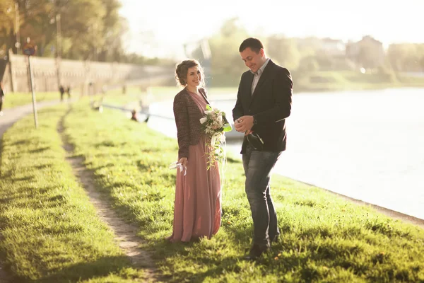 Casamento casal, noivo e vestido posando perto do rio com um copo ao pôr do sol — Fotografia de Stock