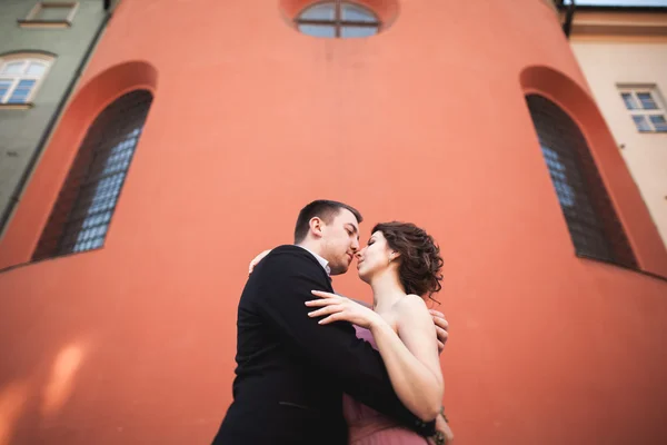 Чудова весільні пара, наречений і наречена з рожевій сукні, ходьба у Старому місті Кракова — стокове фото