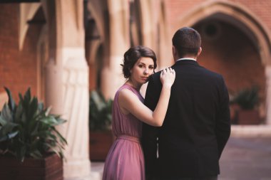 Genç çift aşk gelin ve damat ve arka plan üzerinde beyaz sütun içeren alan yakın poz. Krakow