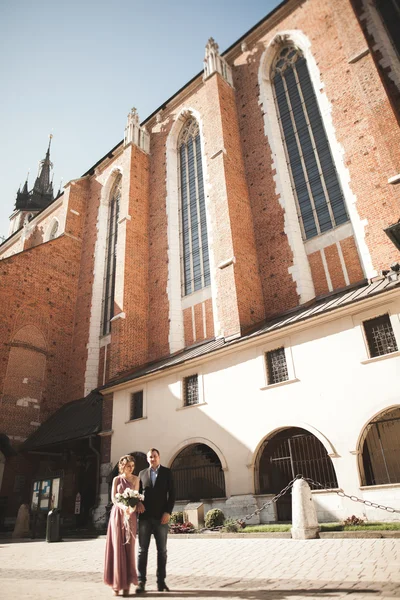 Elegante mooie bruidspaar poseren in de buurt van een kerk. Krakau — Stockfoto