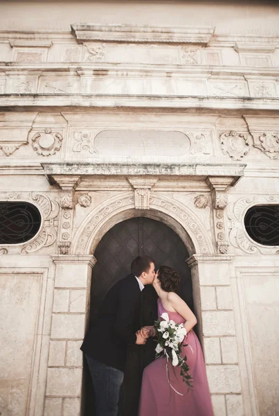 Superbe couple de mariage, marié et mariée avec robe rose marchant dans la vieille ville de Cracovie — Photo