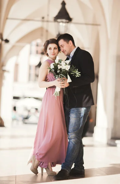 Casal de casamento romântico, homem e mulher, posando perto de coluna de edifício velho — Fotografia de Stock