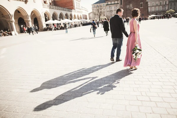 Bröllop. vackert par, brud med rosa brudklänning promenad i den gamla staden Krakow, deras skuggor — Stockfoto