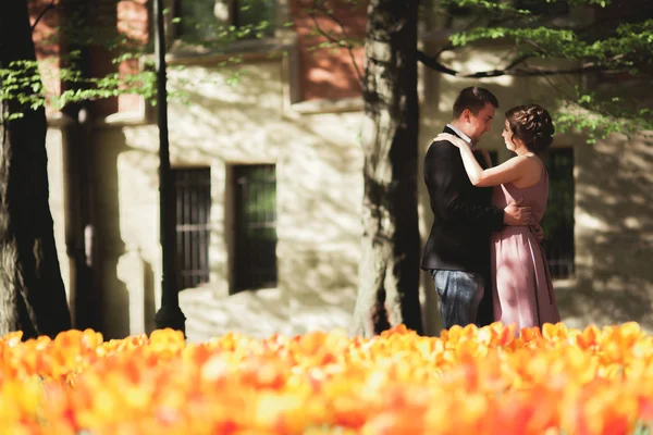 Молодая супружеская пара позирует возле дерева с цветами — стоковое фото