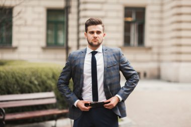 Genç şık işadamı ayarlama onun takım elbise, boyun kravat