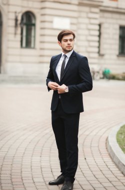 Genç şık işadamı ayarlama onun takım elbise, boyun kravat