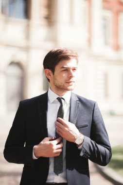 Genç şık işadamı ayarlama onun takım elbise, boyun kravat