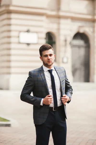 Joven hombre de negocios elegante ajustando su traje, corbata de cuello —  Fotos de Stock