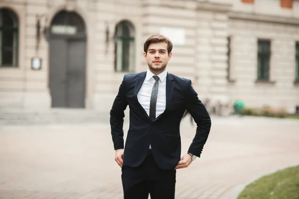 Jovem homem de negócios elegante ajustando seu terno, gravata pescoço — Fotografia de Stock