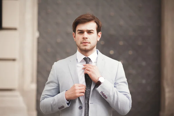 Junge stilvolle Geschäftsmann Anpassung seines Anzugs, Krawatte — Stockfoto