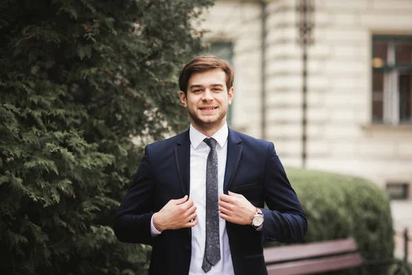 Jovem homem de negócios elegante ajustando seu terno, gravata pescoço — Fotografia de Stock