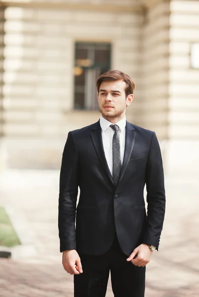 Guapo elegante joven empresario posando retrato al aire libre —  Fotos de Stock