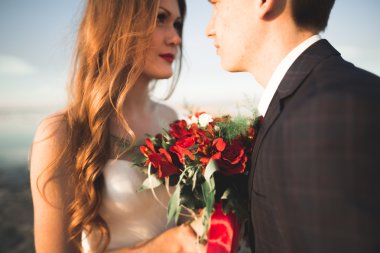 Güzel genç düğün çift, gelin ve damat arka plan denizde ahşap direklerin yakın poz