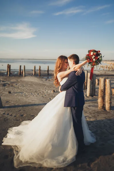 Élégant couple de mariage heureux élégant, mariée, marié magnifique sur le fond de la mer et le ciel — Photo