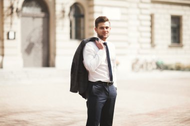 Yakışıklı, şık, genç bir iş adamı. Açık havada portre pozu veriyor.