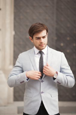 Genç şık işadamı ayarlama onun takım elbise, boyun kravat