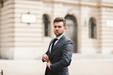 Genç şık işadamı ayarlama onun takım elbise, boyun kravat