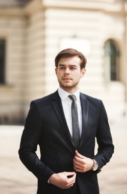 Genç şık işadamı ayarlama onun takım elbise, boyun kravat