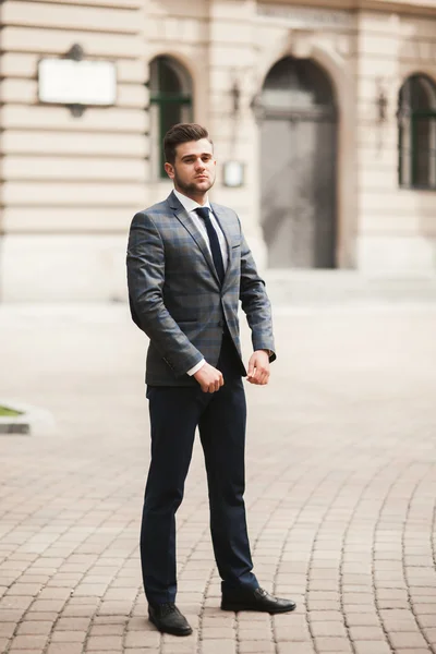 Jovem homem de negócios elegante ajustando seu terno, gravata pescoço — Fotografia de Stock