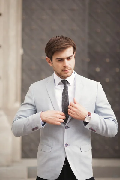 Joven hombre de negocios elegante ajustando su traje, corbata de cuello —  Fotos de Stock