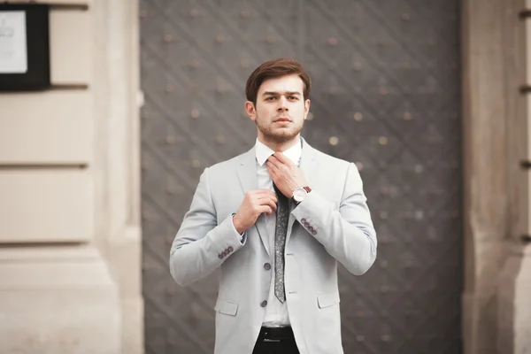 Jovem homem de negócios elegante ajustando seu terno, gravata pescoço — Fotografia de Stock