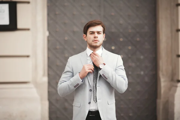 Joven hombre de negocios elegante ajustando su traje, corbata de cuello —  Fotos de Stock