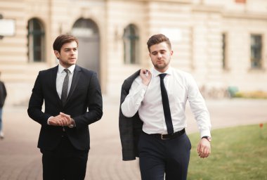 Konuşma ve açık havada gülümseyen iki şık iş adamları