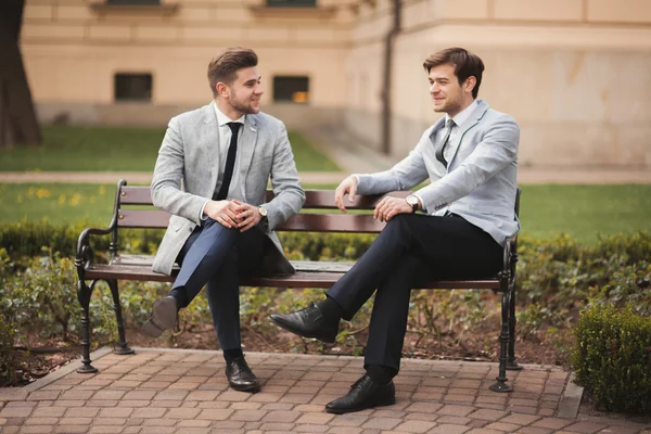 Δύο κομψά επιχειρηματιών μιλώντας και χαμογελώντας σε εξωτερικούς χώρους — Φωτογραφία Αρχείου
