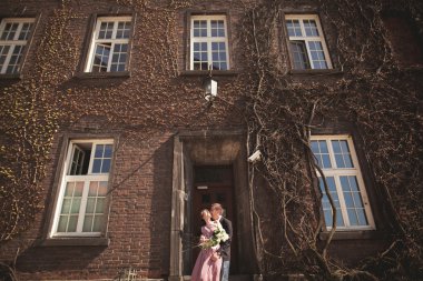 Genç düğün iki aşk hikayesi, gelin ve damat arka planda bina yakın poz sonra. Krakow