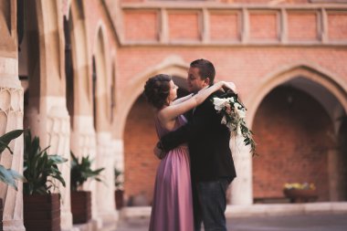 Genç çift aşk gelin ve damat ve arka plan üzerinde beyaz sütun içeren alan yakın poz. Krakow