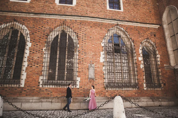 Elegantní krásné svatební pár pózuje v blízkosti kostela. Krakov — Stock fotografie