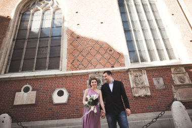 Yanında bir kilise poz zarif güzel düğün çifti. Krakow
