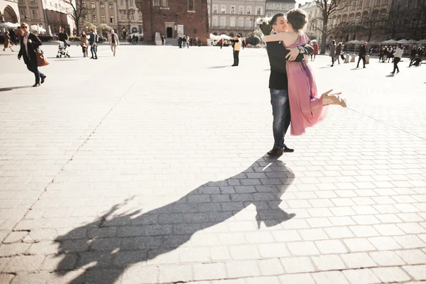 Casamento. belo casal, noiva com vestido rosa andando na cidade velha Cracóvia, suas sombras — Fotografia de Stock